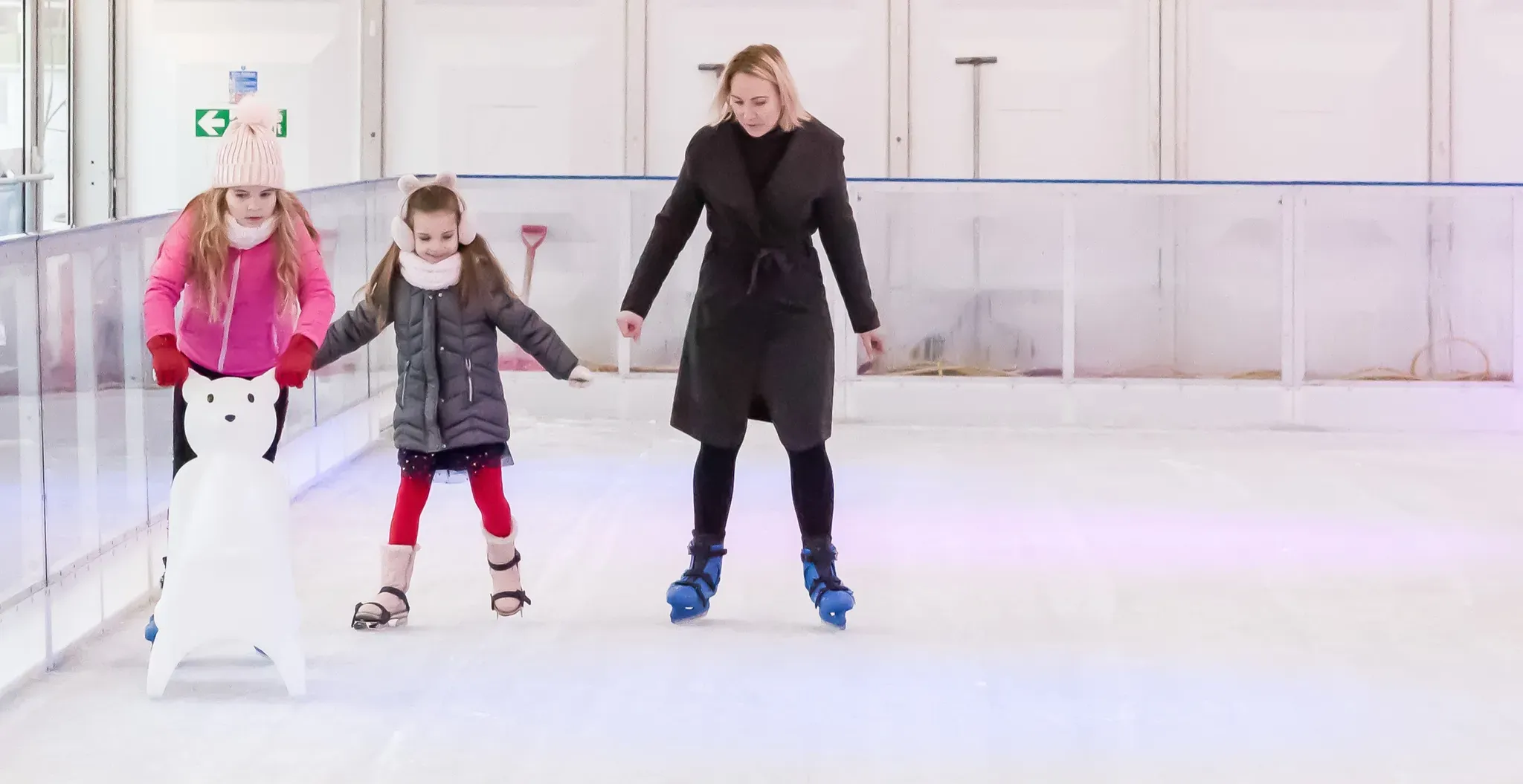 A mother skating with her two daughters and a skating aid in Corby