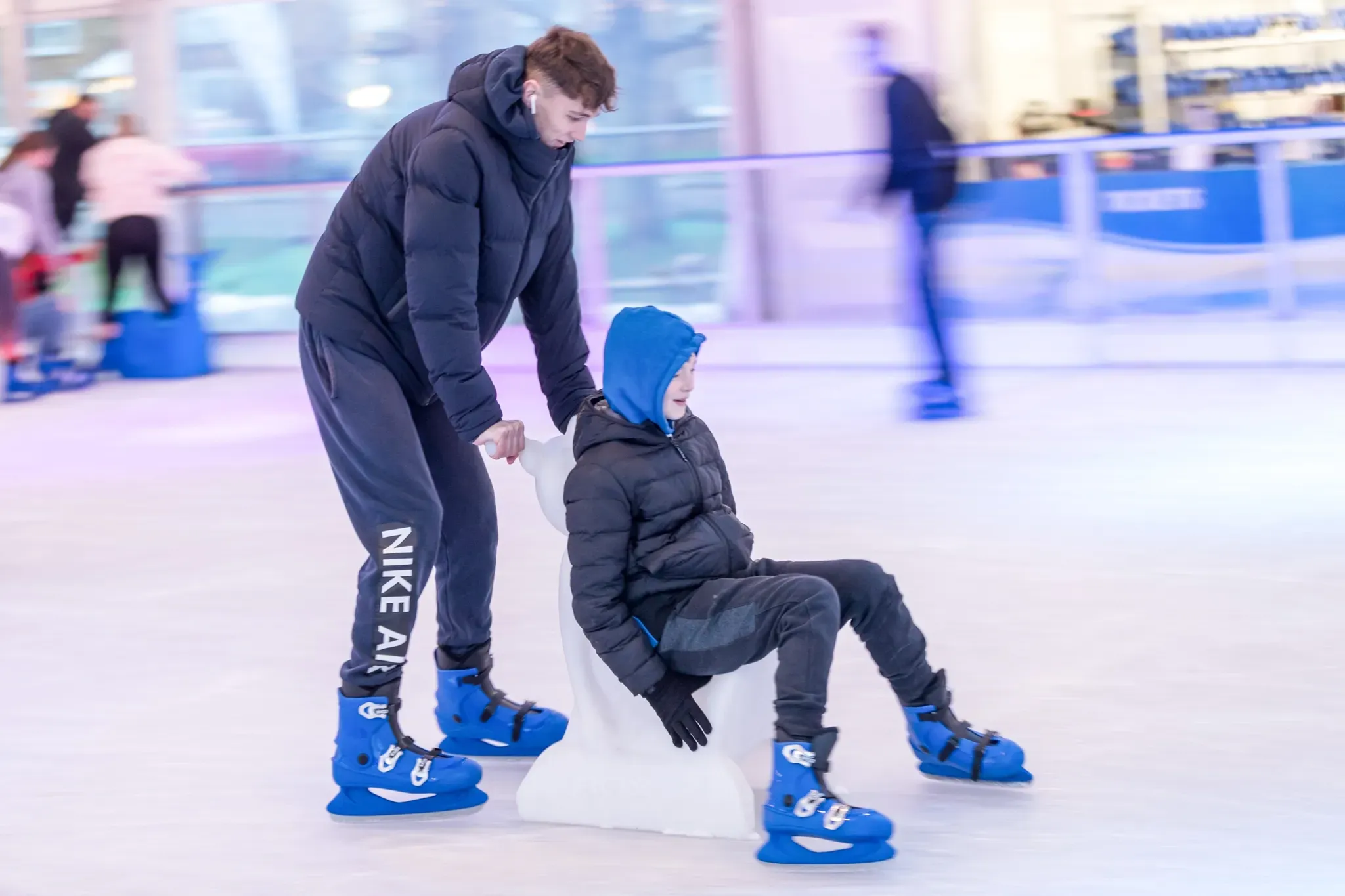A skater helping a child up on the Corby rink