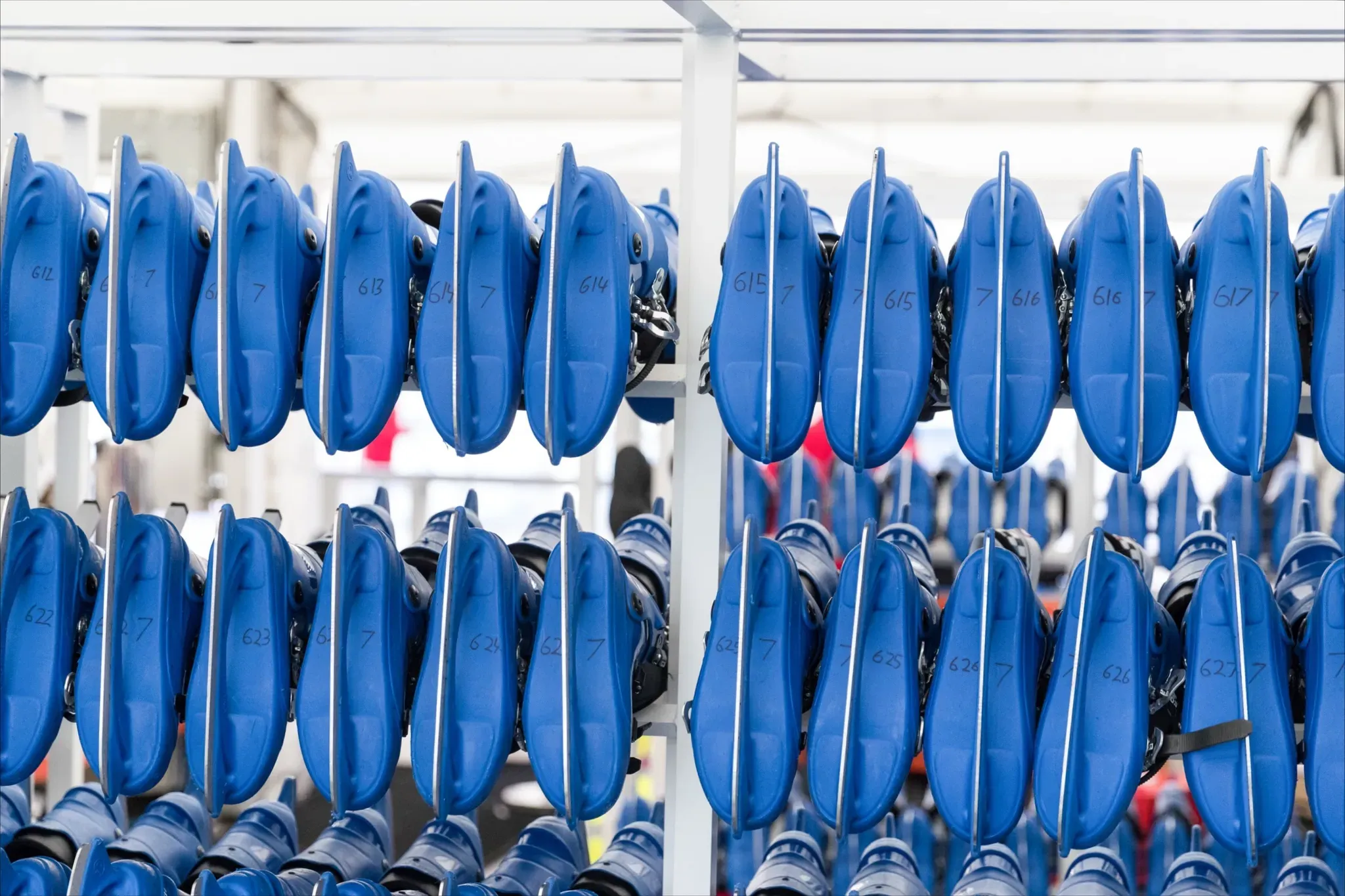 Rows of numbered blue rental skates on a skate hire rack