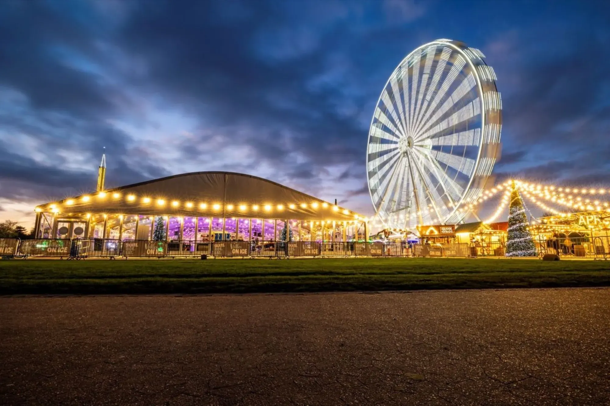 Willen On Ice at dusk: the rink marquee, observation wheel and lakeside fairground