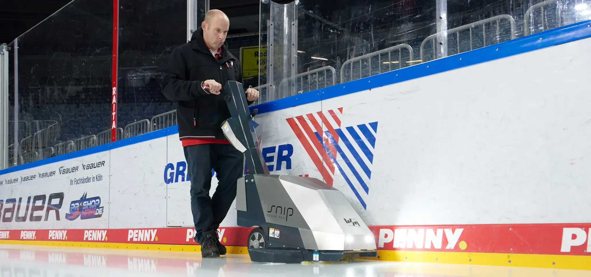 An operator edging an arena rink with the WM Technics Snip