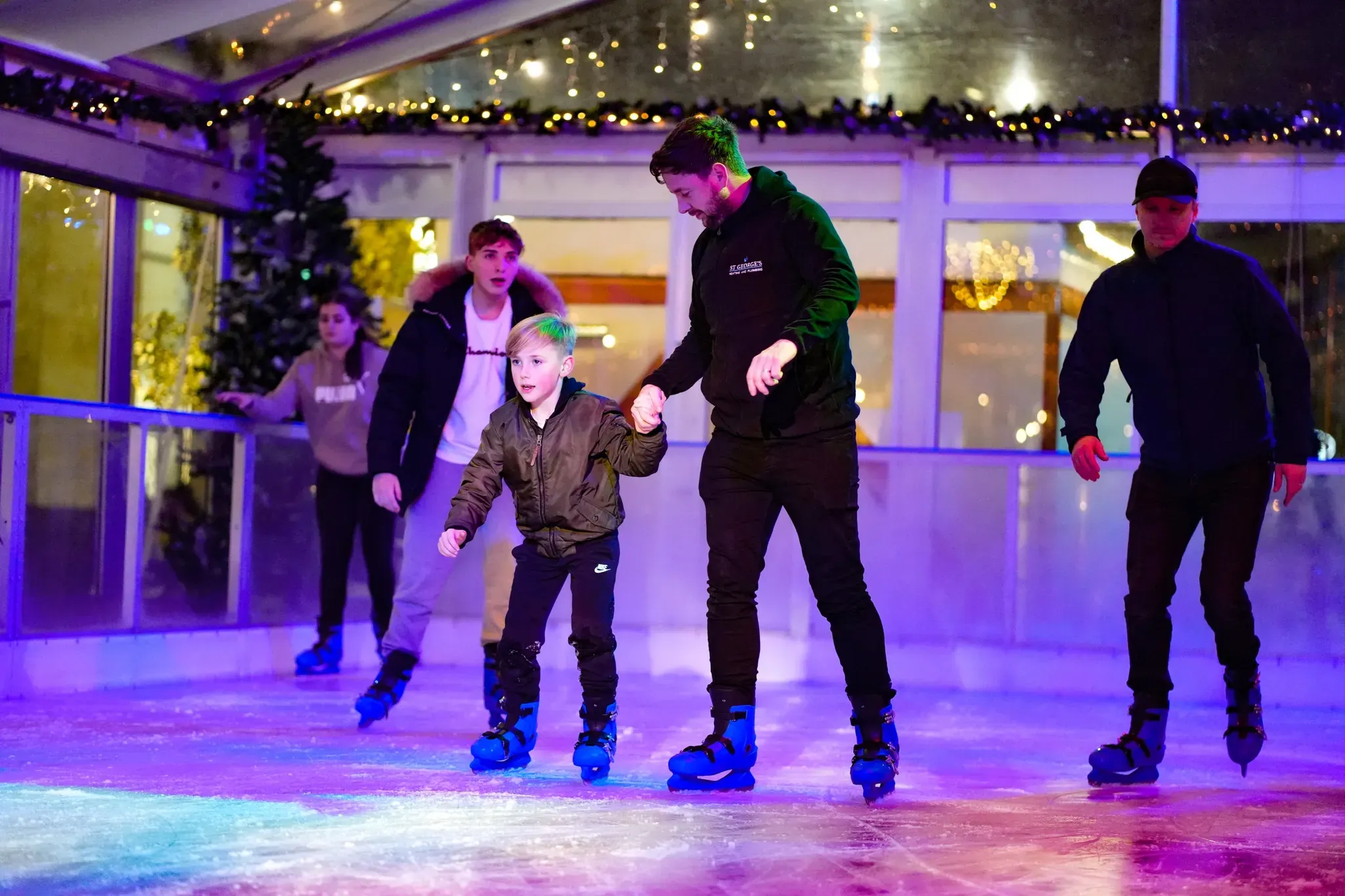 A father helping his son skate in Woking
